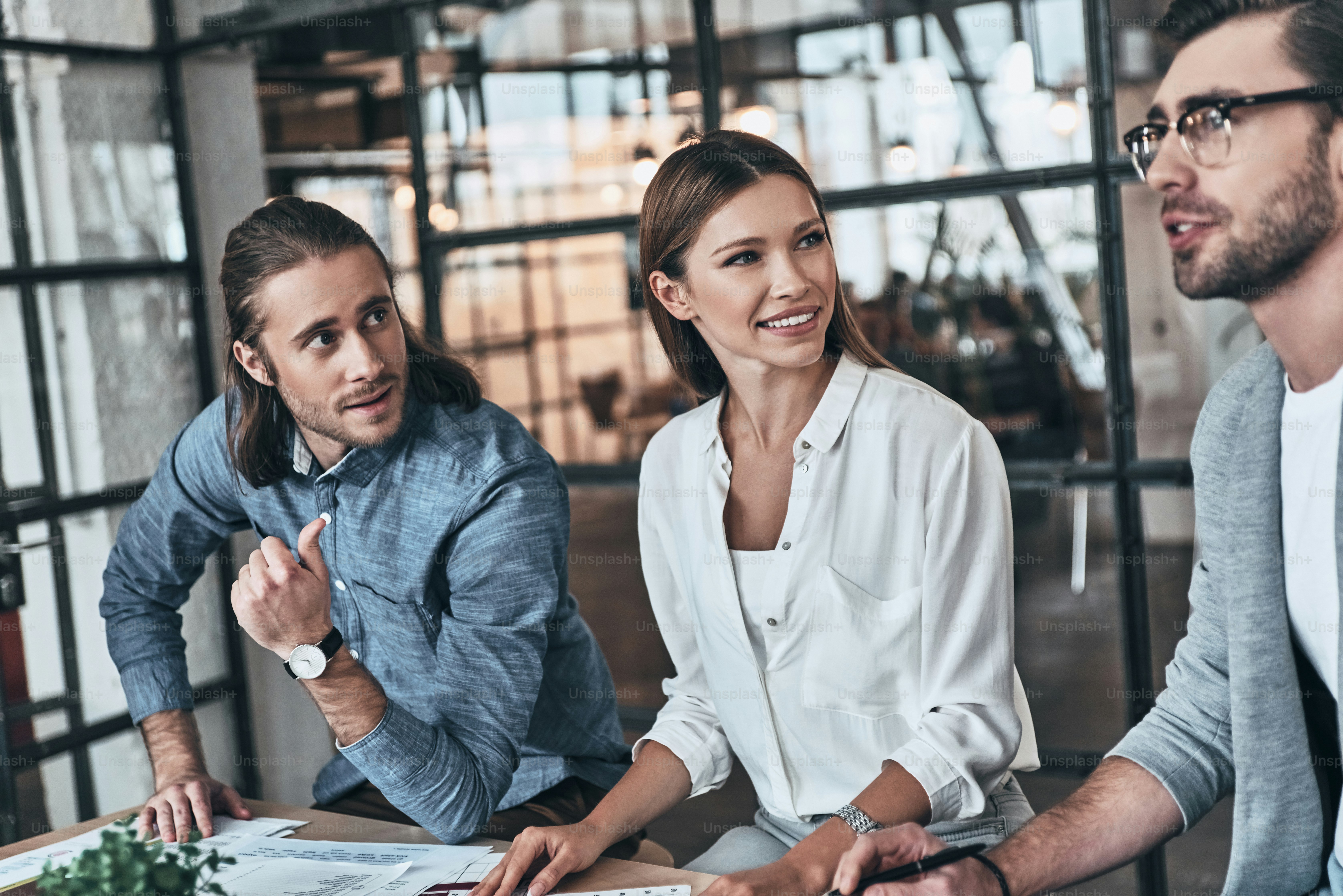 Group of young business people working and communicating while sitting in the office