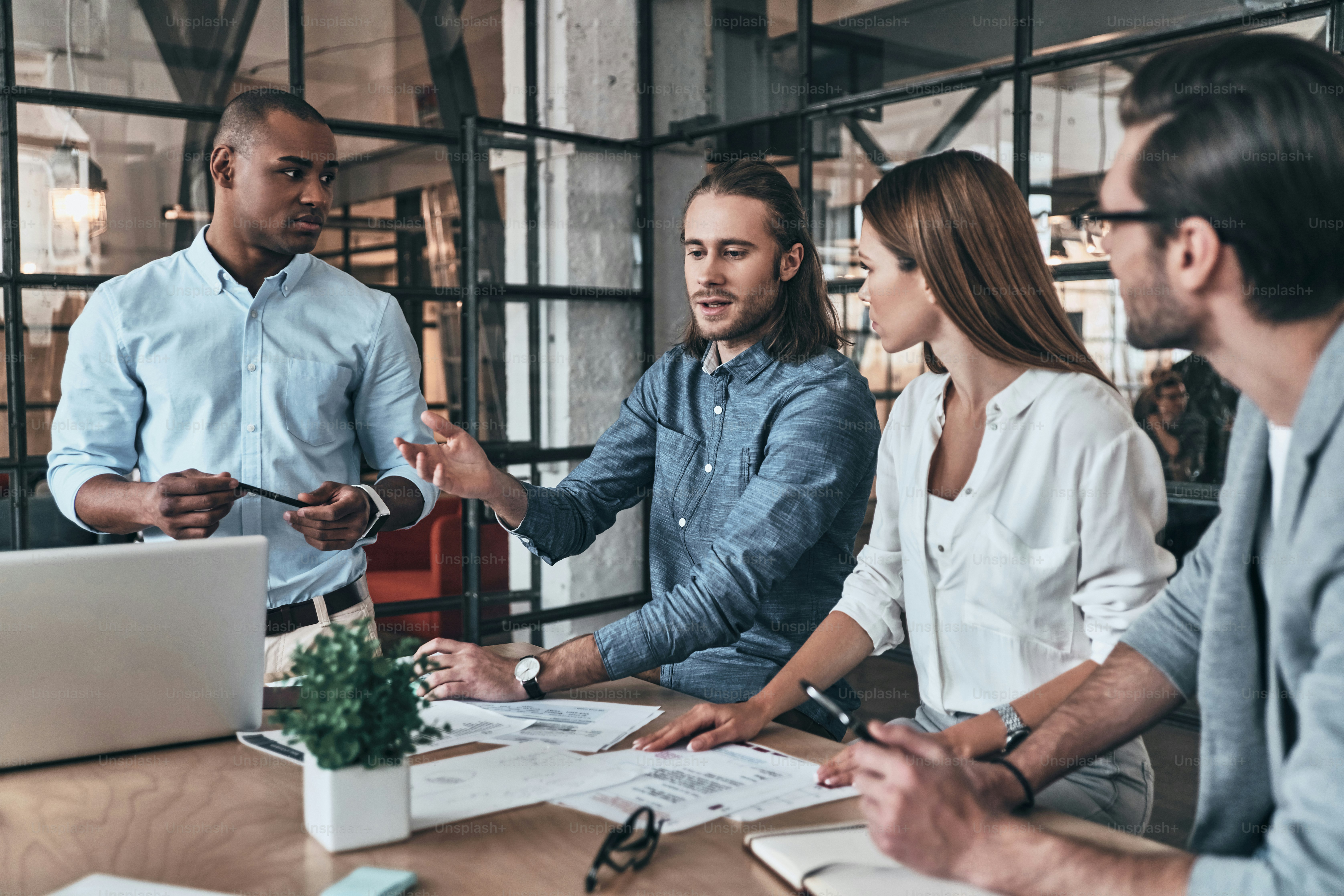 Group of young business people discussing something while sitting in the office