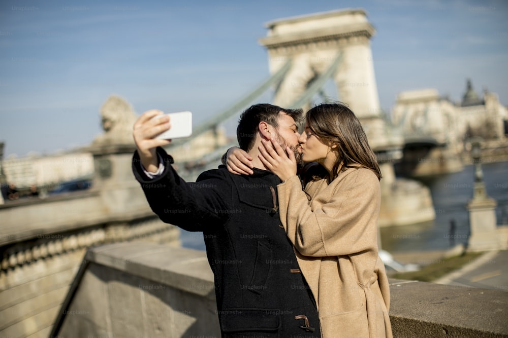 Retrato de casal amoroso tirando selfie em ambiente urbano