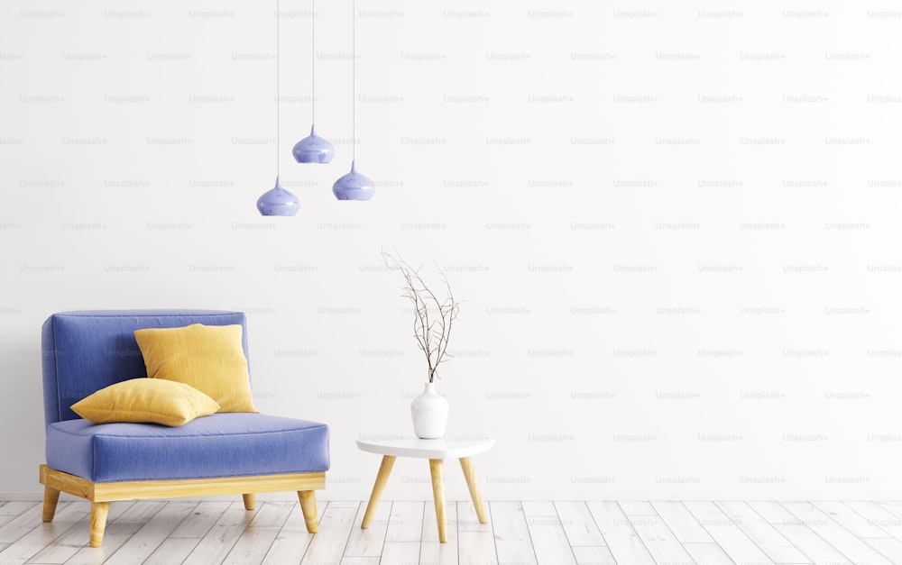 Intérieur du salon avec fauteuil velours bleu, coussins jaunes, table en bois avec vase et lampes sur rendu 3D mural blanc