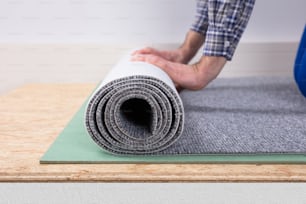 Gros plan de la main d’un travailleur installant un tapis