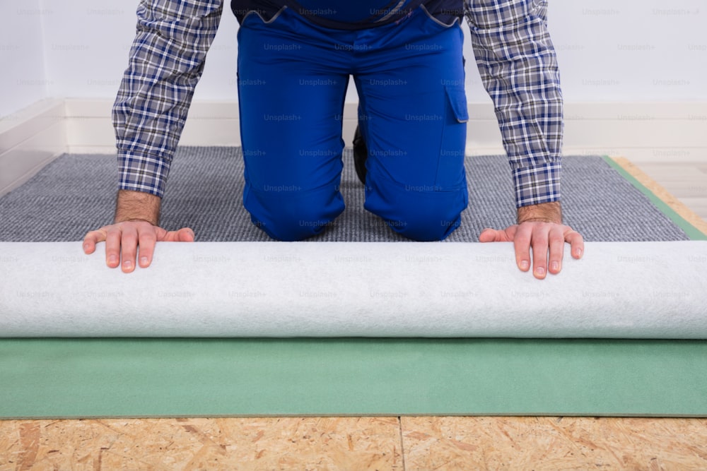 Close-up Of A Male Worker's Hand Installing Carpet