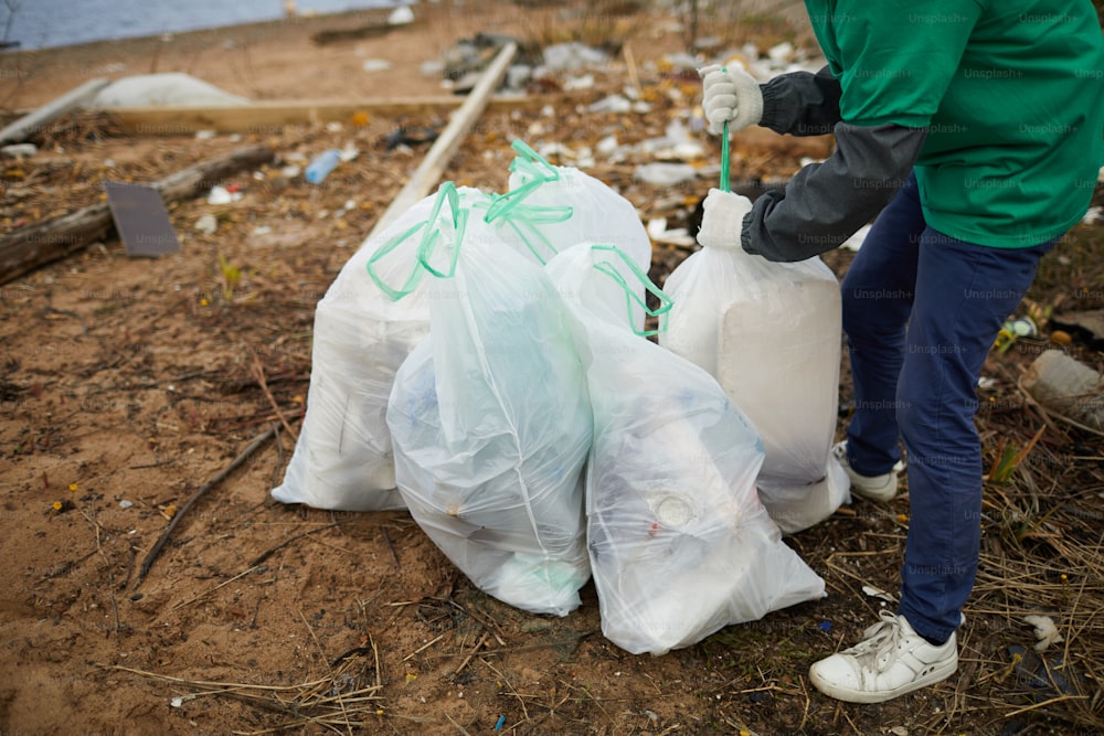 그린피스 단체의 노동자가 더 많은 활용을 위해 쓰레기와 함께 자루를 준비하고 있습니다.