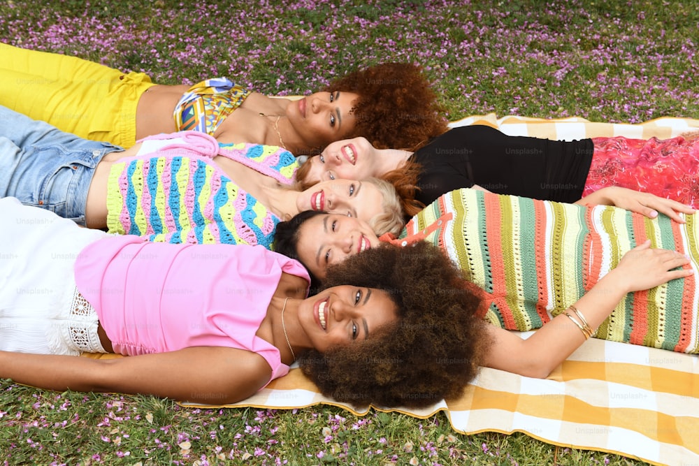 um grupo de mulheres deitadas em cima de um cobertor