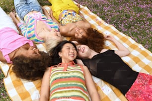 a group of women laying on top of a blanket