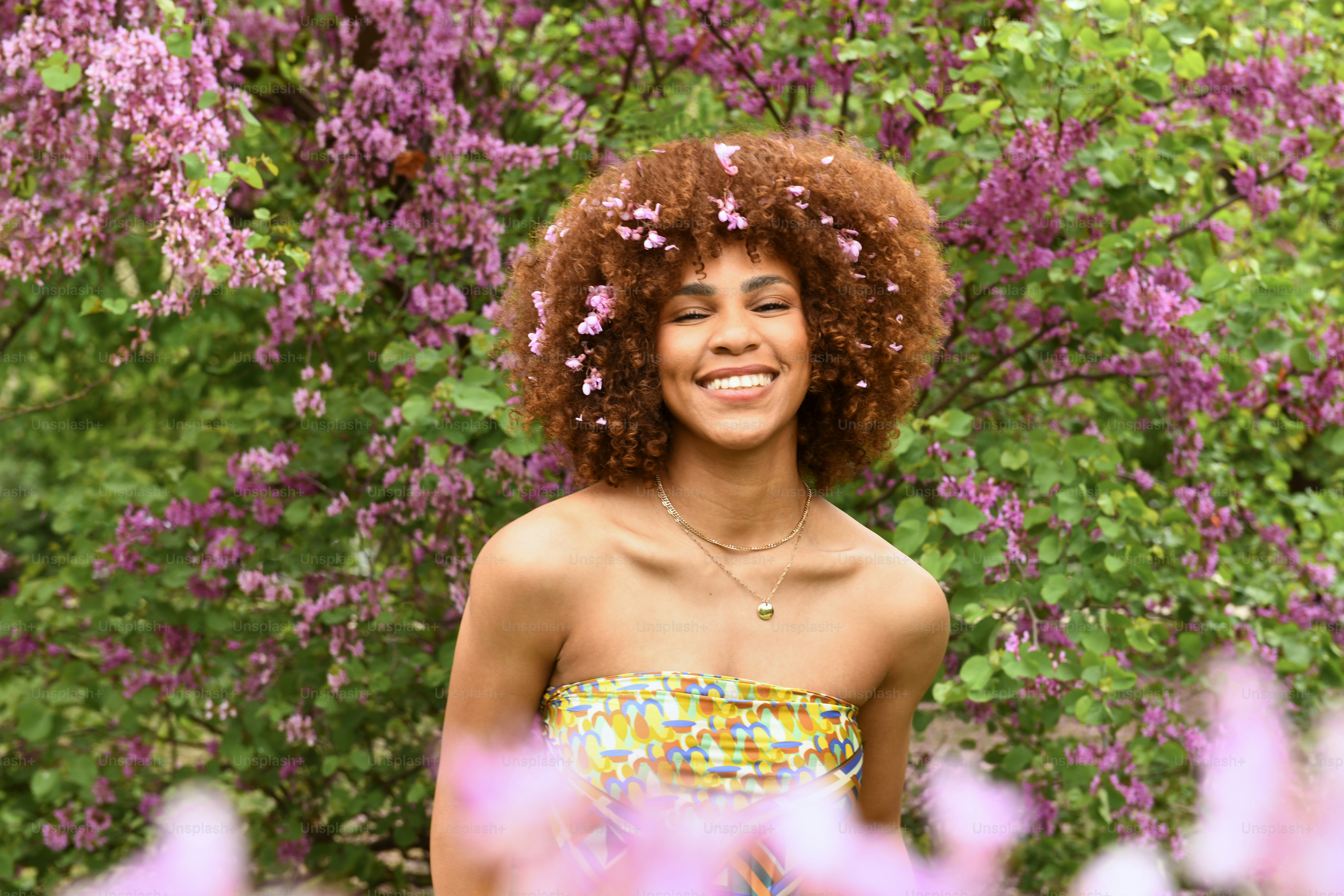 紫色の花の前に立つ女性