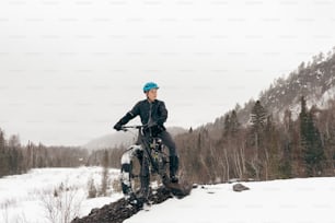 a man riding a bike on top of a snow covered slope