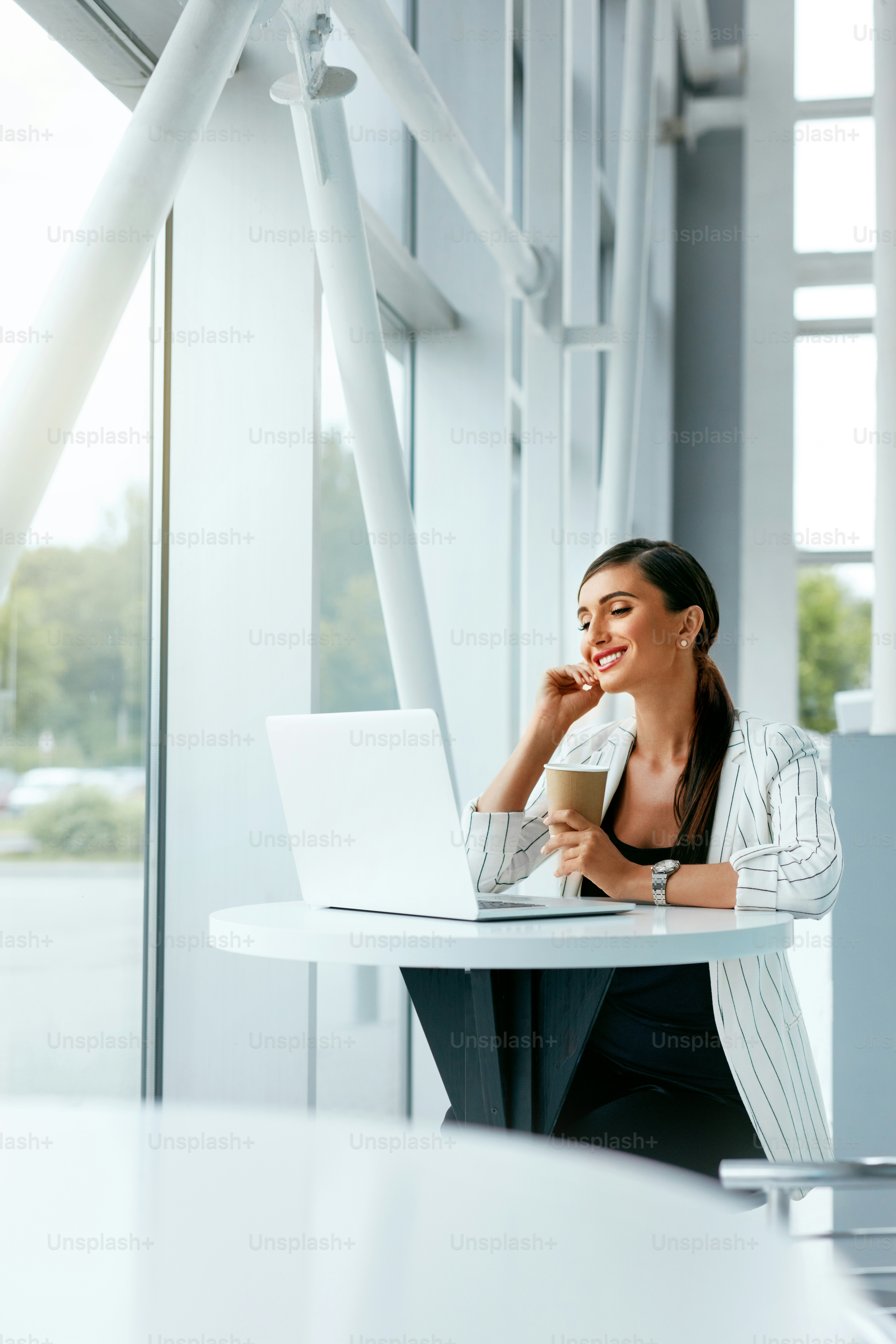 Woman Working On Notebook, Using Phone In Office. Beautiful Business Woman Work Indoors At Cafe. High Resolution
