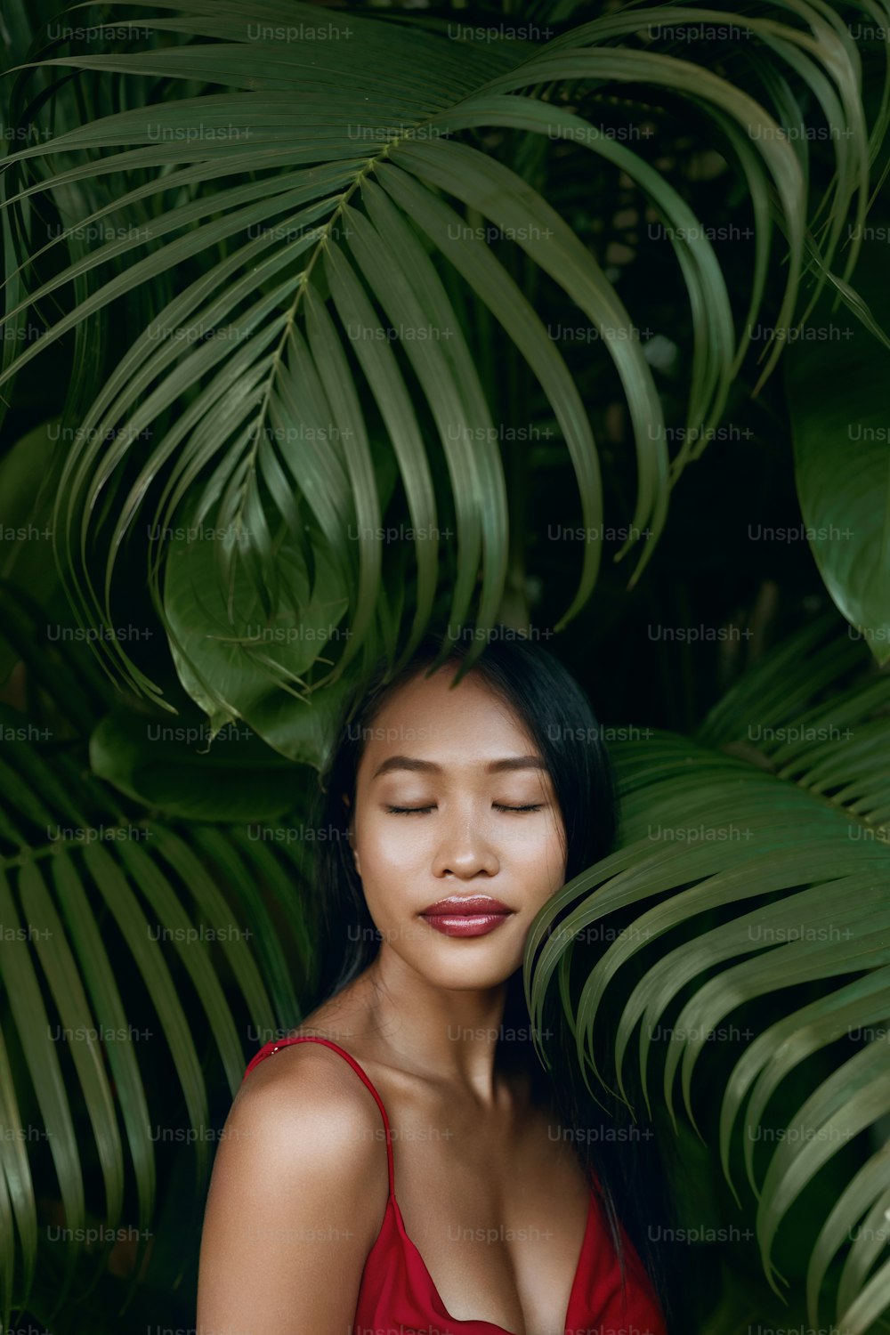 Belleza. Mujer asiática con hermoso rostro y retrato de hojas de palma natural. Modelo de niña en la naturaleza tropical al aire libre