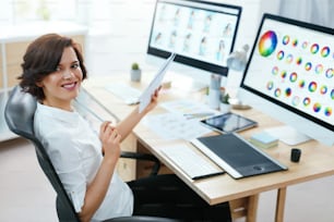 Designerin, die im Büro am Computer arbeitet. Weiblich arbeitet an einem Webdesign-Projekt mit Illustrationen. Hohe Auflösung