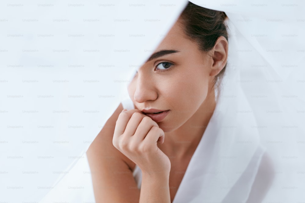 Schönheit Gesichtspflege. Frau mit schöner Haut und natürlichem Make-up in weißer Innennahaufnahme. Hohe Auflösung
