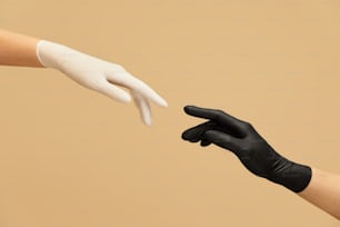 手のジェスチャー。検疫中の手袋での挨拶。ベージュの背景に触れる前に指を伸ばす手。感染予防のための個人保護。