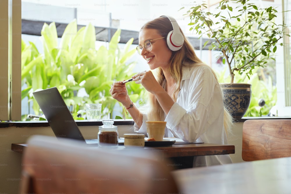 Business. Woman At Coffee Shop Having Online Meeting. Beautiful Model In Glasses Enjoying Summer Vacation And Working At Cafe. Remote Education Or Modern Creativity Job At Comfortable Workplace.