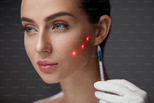 Beauty Injection. Beautiful Woman's Face With Red Laser Points On Skin Receiving Facial Skin Injections. Closeup Of Hand With Syringe Doing Hyaluronic Puncture. Cosmetic Treatment. High Resolution