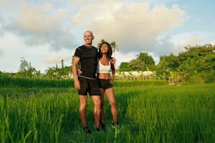 Mature Couple’s Standing On Rice Field Portrait. Caucasian Man And Asian Woman Resting After Workout In Morning Against Tropical Landscape.