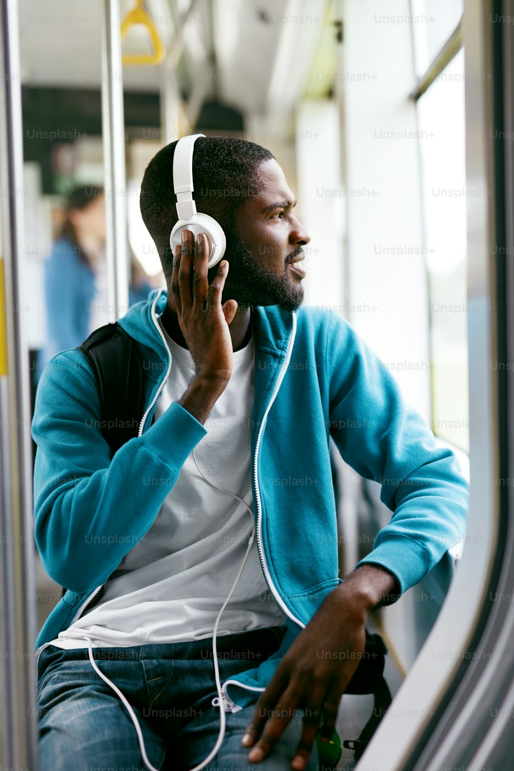 Uomo in cuffia ascoltando musica Riding nei trasporti pubblici. Bello maschio nero che viaggia in autobus. Alta risoluzione