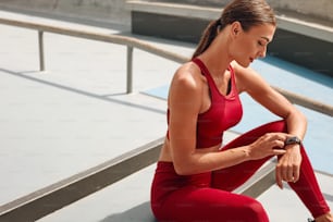 Fitness. Woman Checking Smart Watch Before Workout. Fit Girl With Perfect Body In Fashion Sportswear Using Tracker On Her Wrist. Technologies For Monitoring Fitness Progress And Healthy Lifestyle.