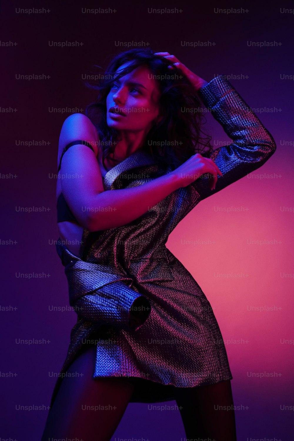 Modelo de mujer de moda en vestido de moda con luces de neón de colores en el estudio. Retrato de una chica sexy con estilo con ropa de moda sobre luz ultravioleta rosa brillante y púrpura en un club nocturno. Estilo