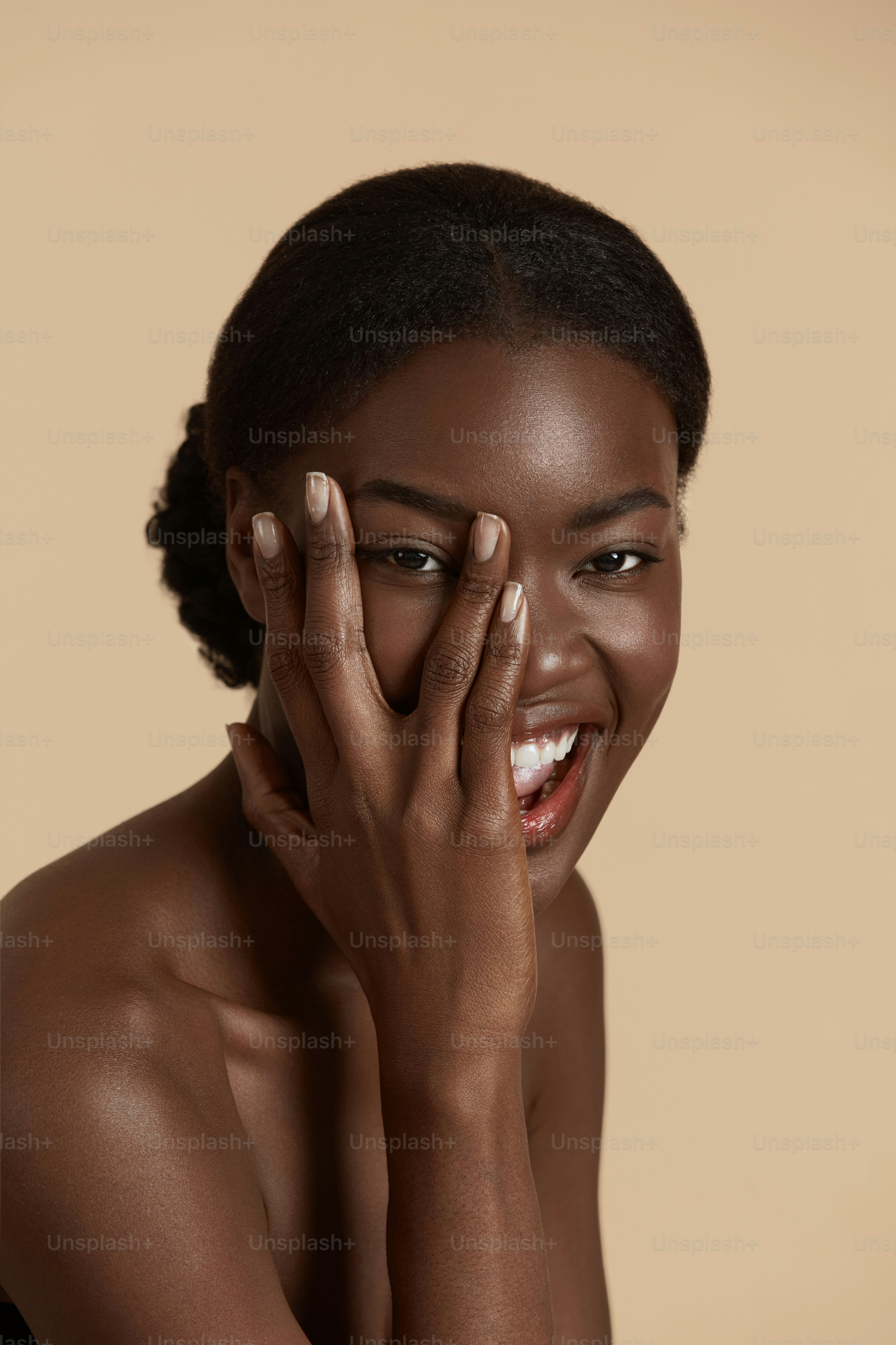 Portrait close up of beautiful african girl. Smiling young woman touch her  clean face and looking at camera. Concept of face skin care. Isolated on  beige background. Studio shoot photo – Face, image size:3000x4500