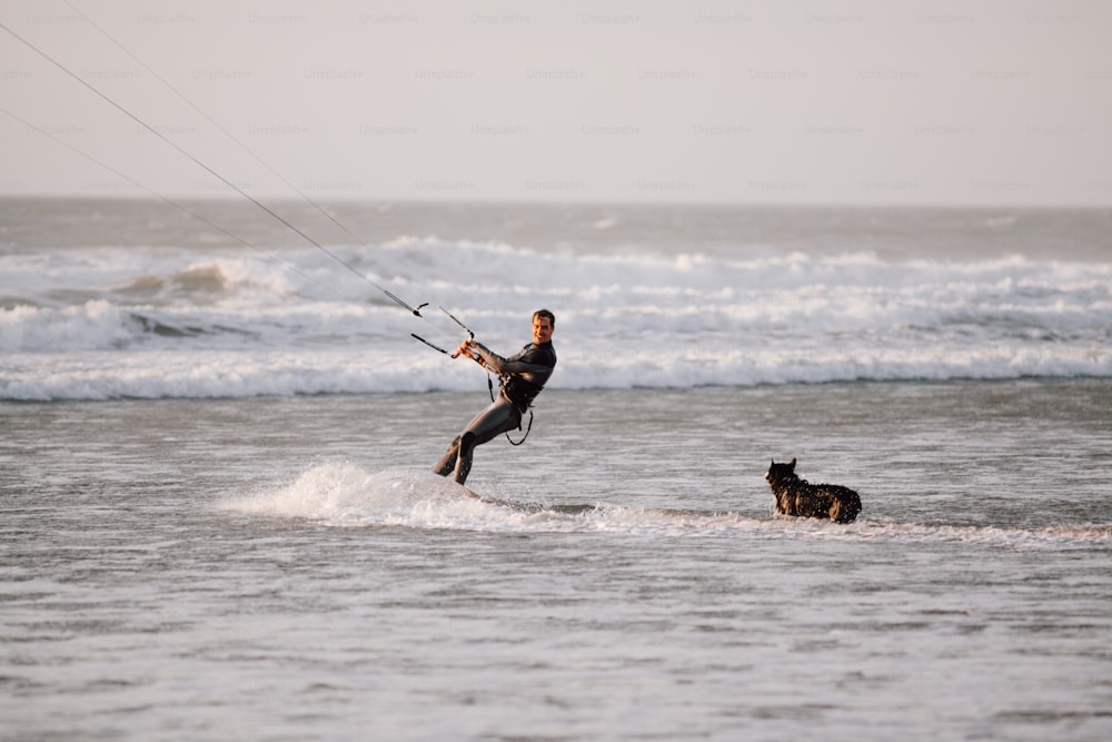 Ein Mann, der mit einem Hund im Meer segelt