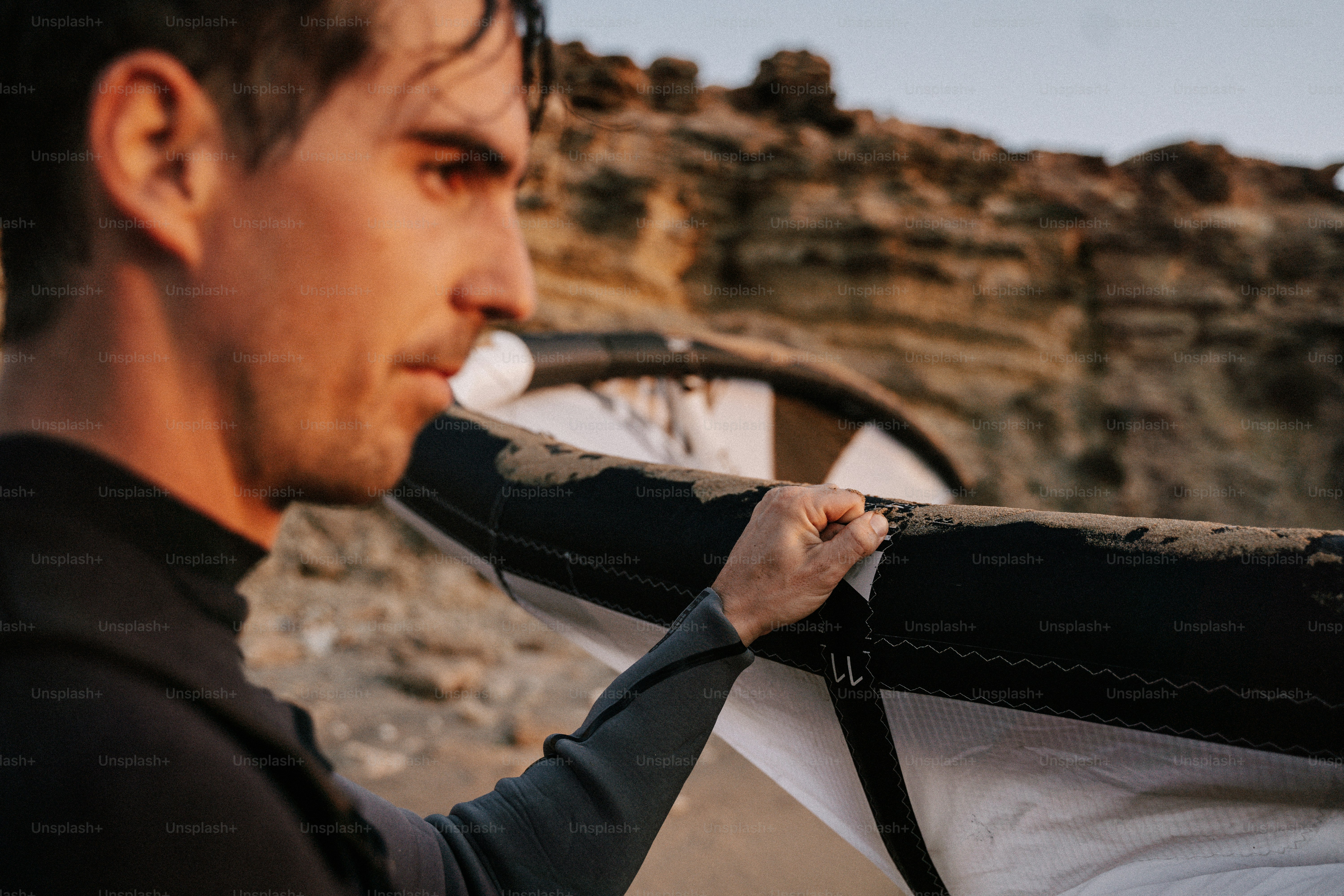Ein Mann, der ein Surfbrett am Strand hält