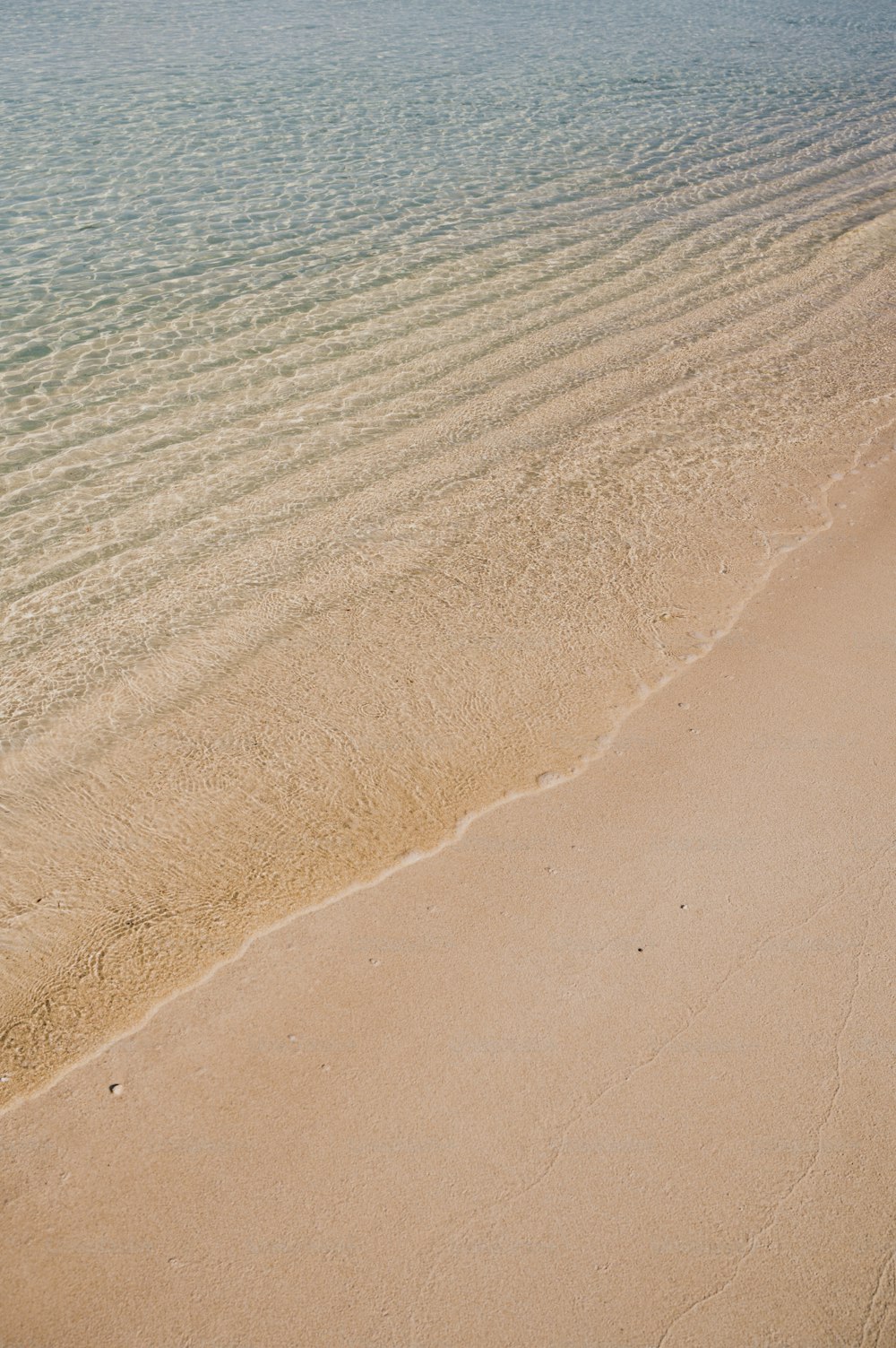 ein Sandstrand mit einem Gewässer im Hintergrund
