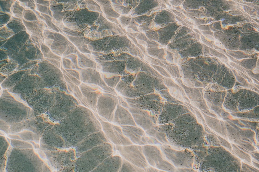 the water is reflecting the sunlight on the sand