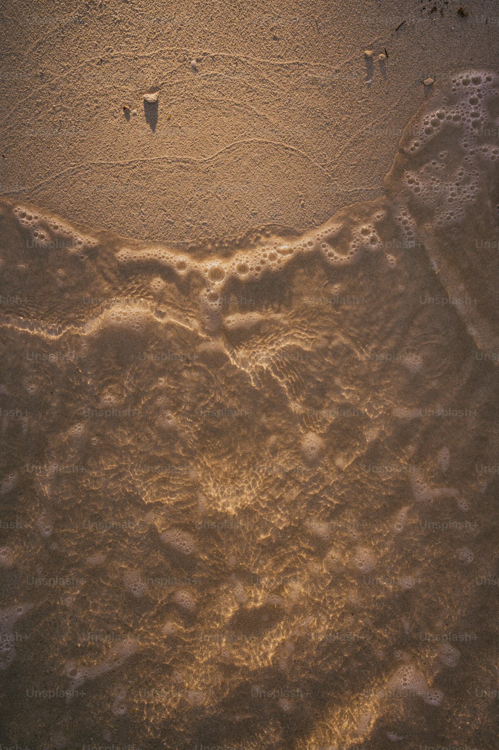 Ein Sandstrand mit Fußabdrücken im Sand