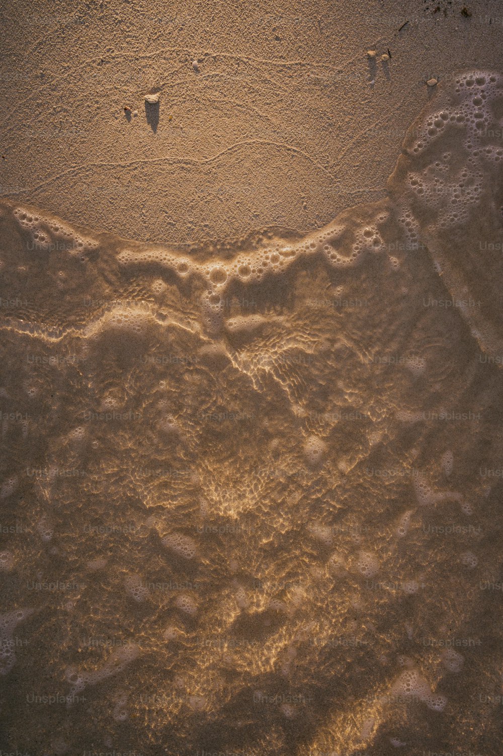 a sandy beach with footprints in the sand