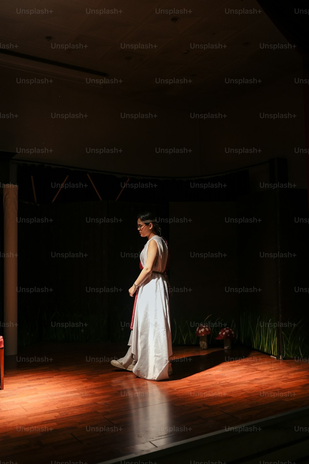 a woman in a white dress standing on a stage