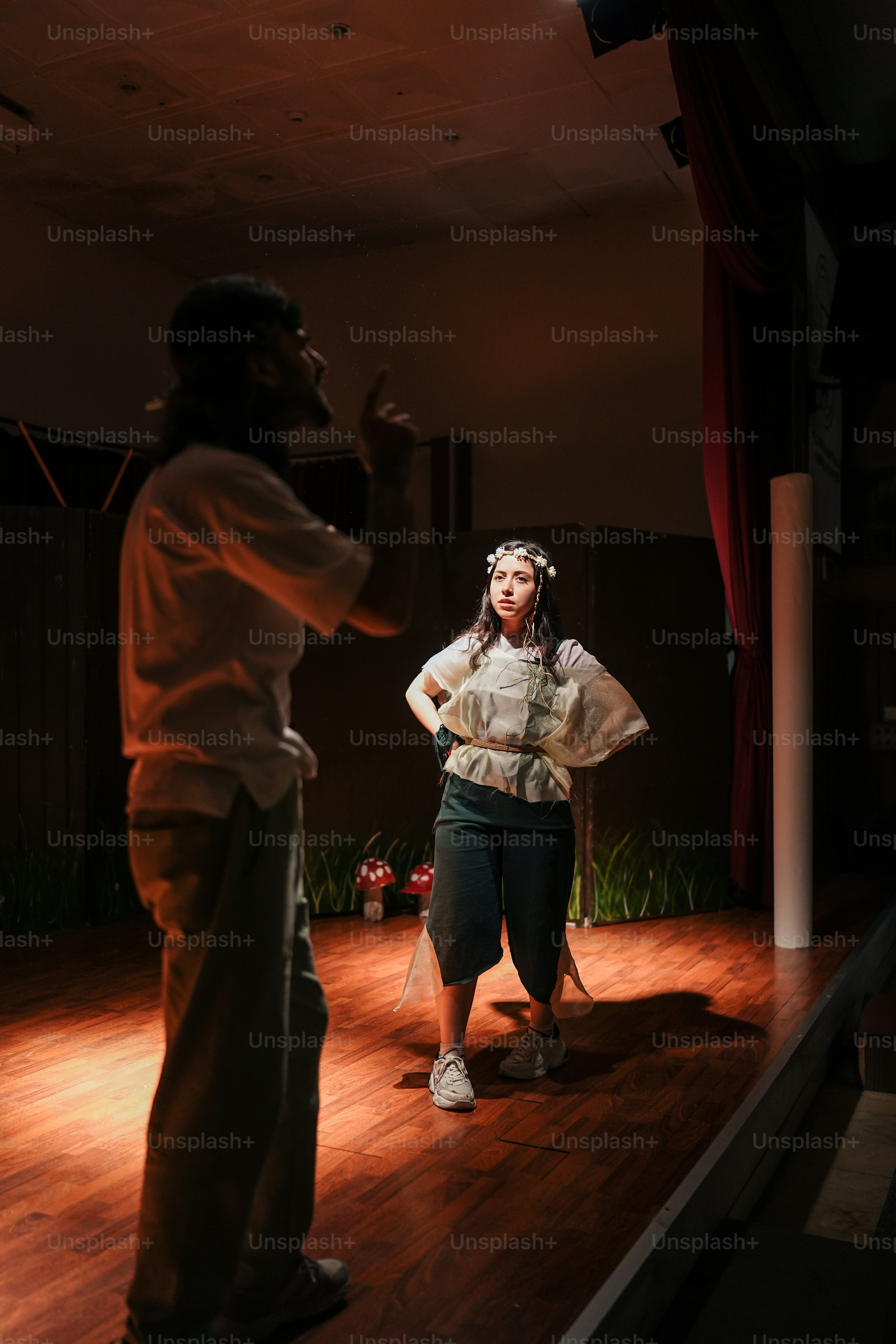 a woman standing on a wooden floor next to a man