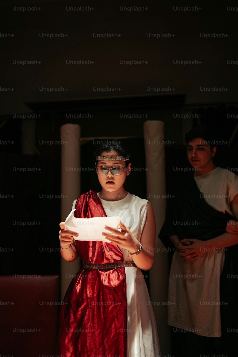 a woman in a red dress holding a piece of paper