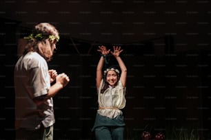 two people standing on a stage with their hands in the air
