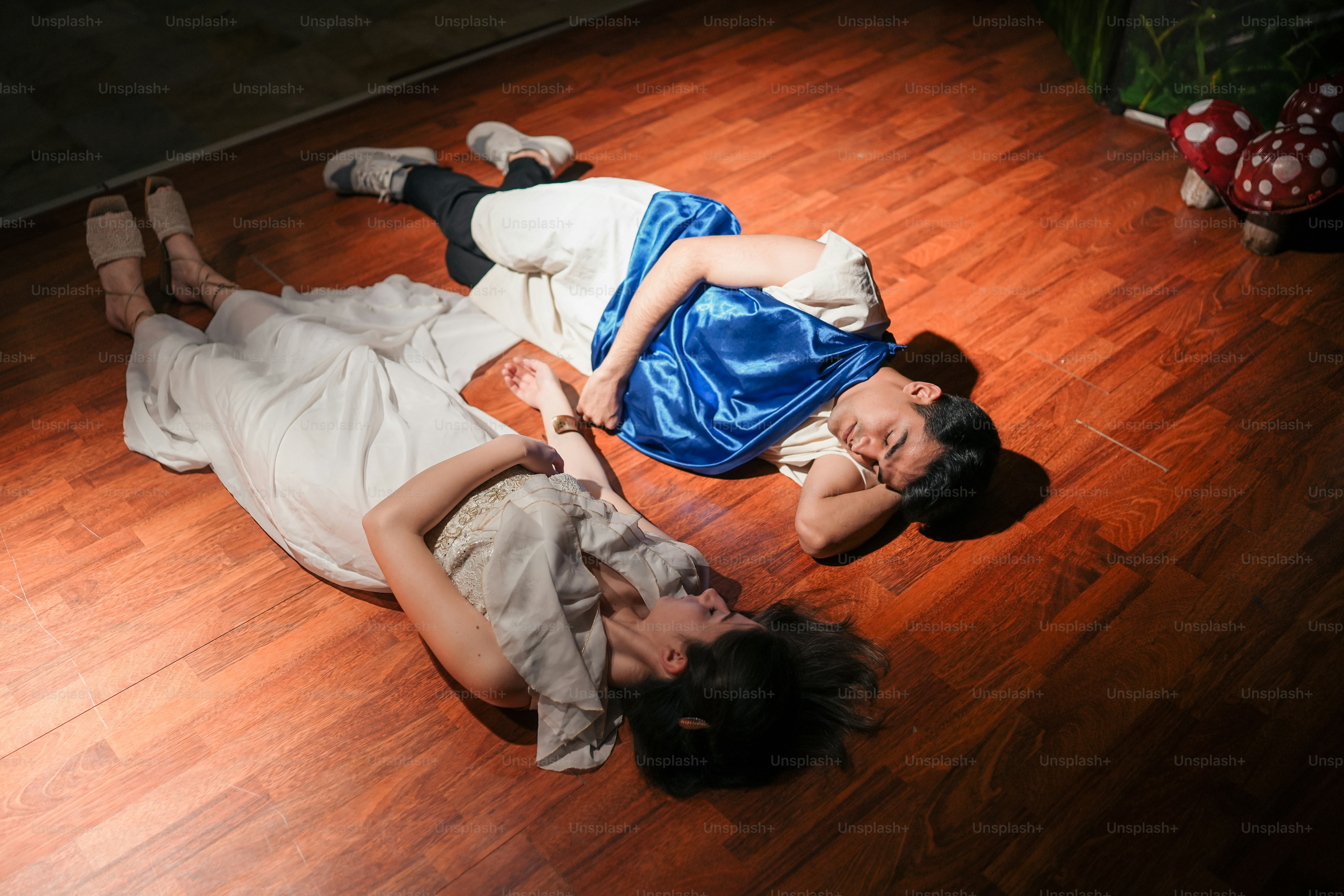Ein paar Leute, die auf einem Holzboden liegen