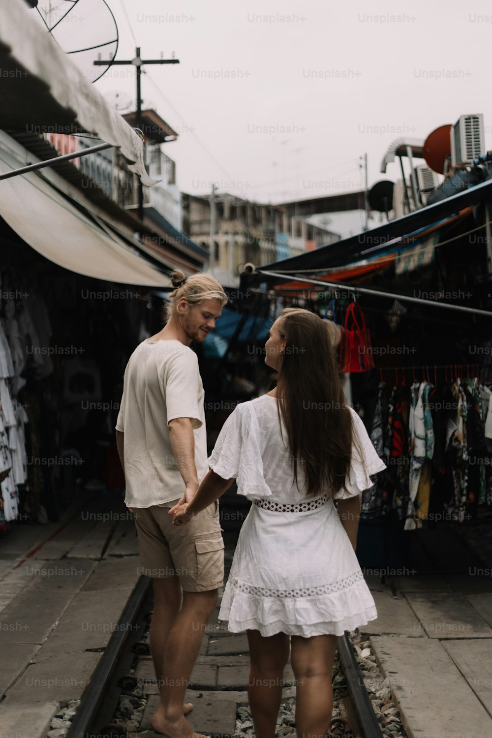 Un homme et une femme marchant sur une voie ferrée