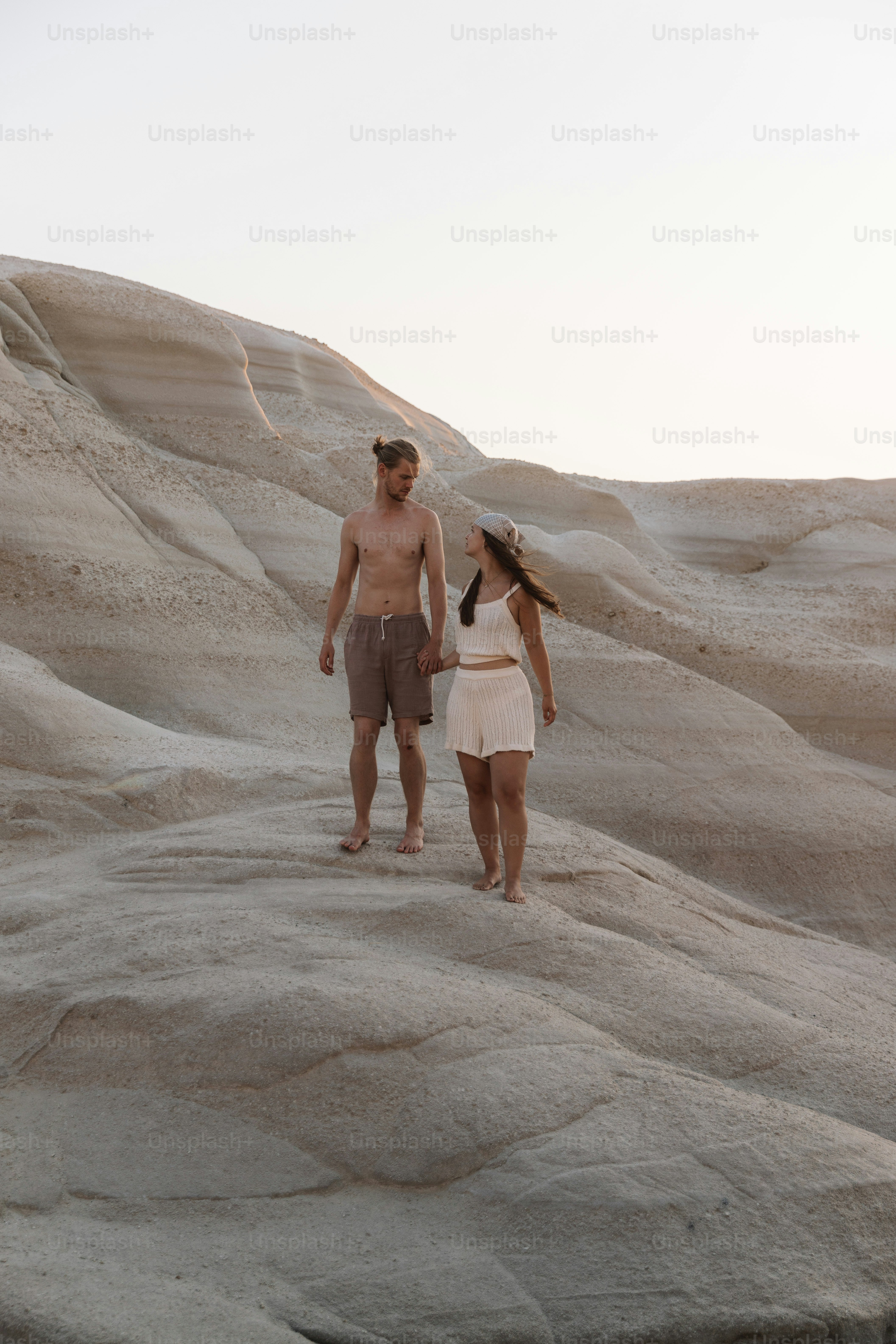a man and a woman are walking in the desert