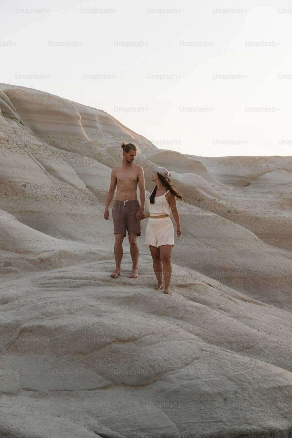um homem e uma mulher estão andando no deserto