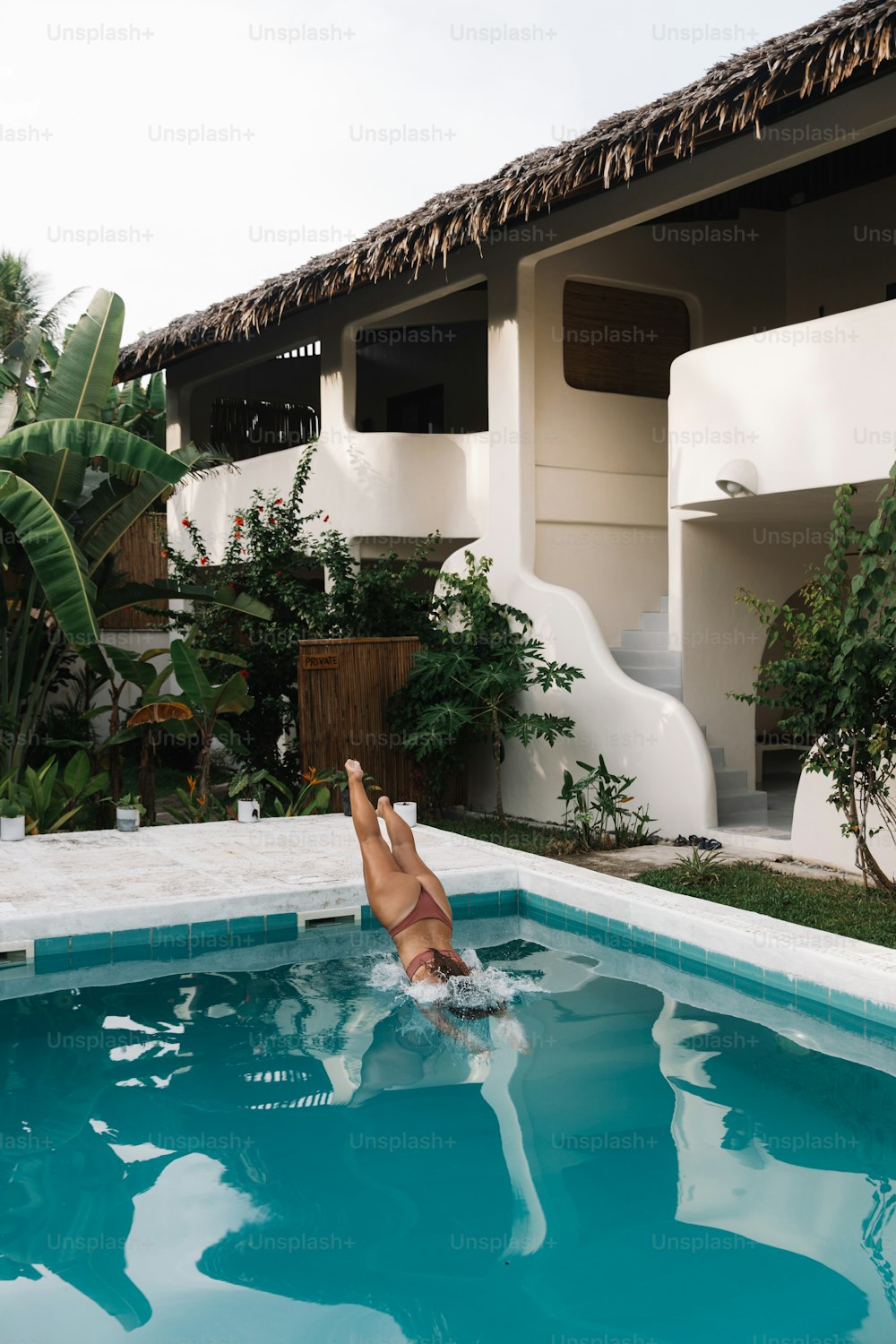 a woman in a swimming pool in front of a house