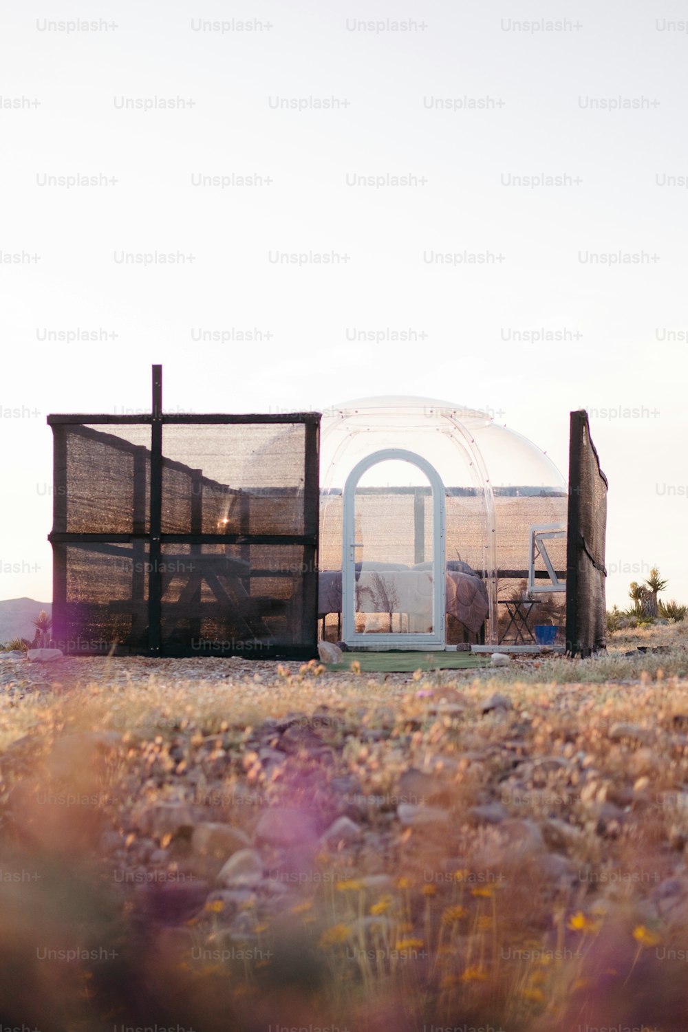 Una pequeña cúpula blanca sentada en la parte superior de un campo cubierto de hierba