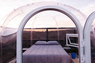 uma cama sentada dentro de uma tenda ao lado de uma janela