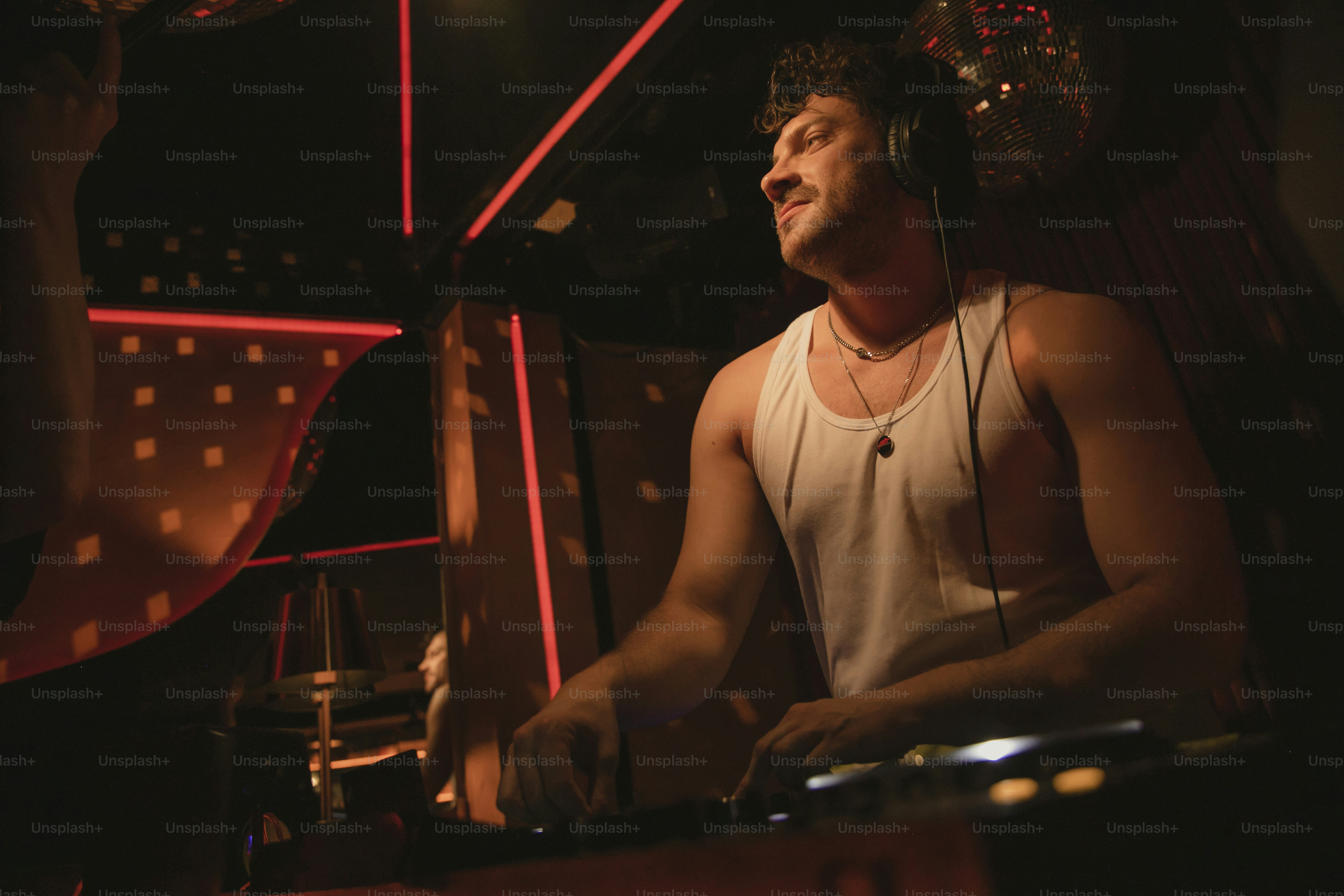 Seorang pria dengan tank top memainkan set DJ