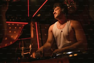 Un hombre en una camiseta sin mangas tocando un set de DJ