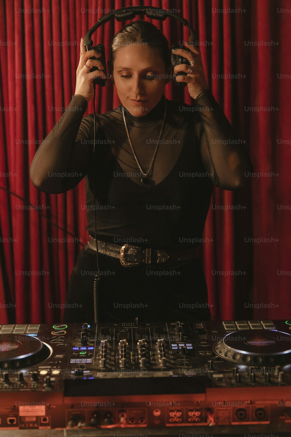 검은색 상의를 입은 여자가 DJ 세트를 연주하고 있다
