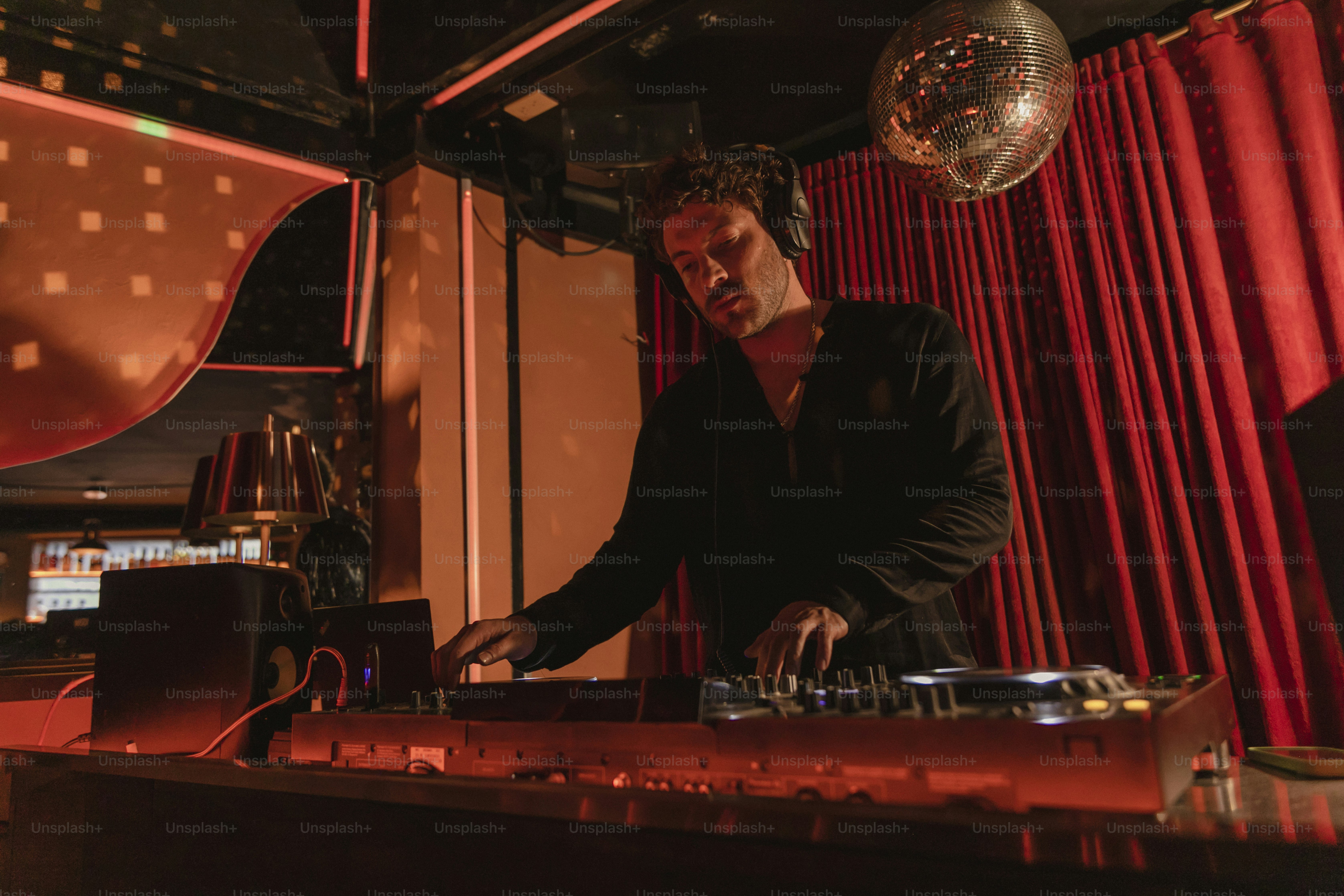 ein Mann, der vor dem Mischpult eines DJs steht