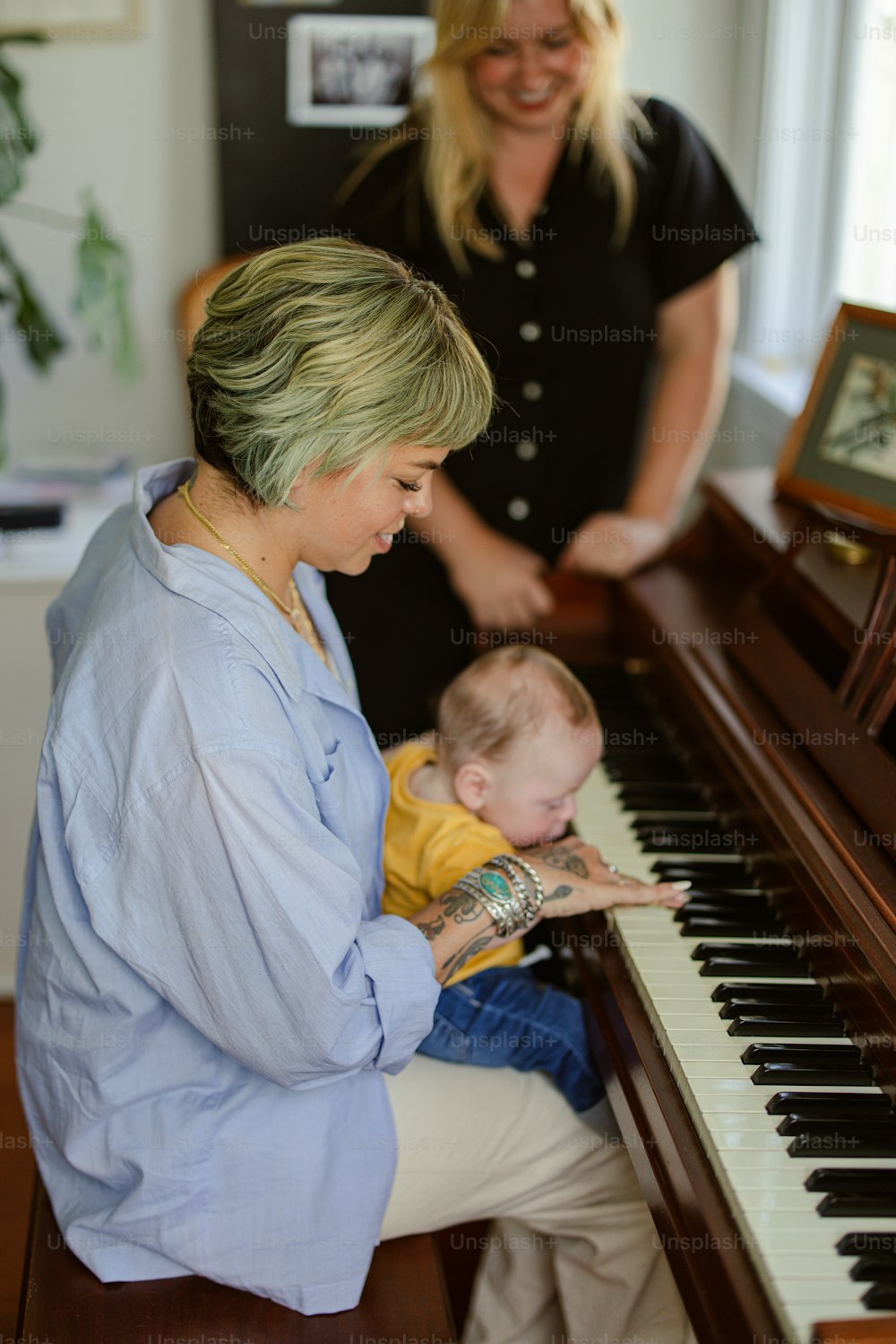 a woman playing a piano with a baby