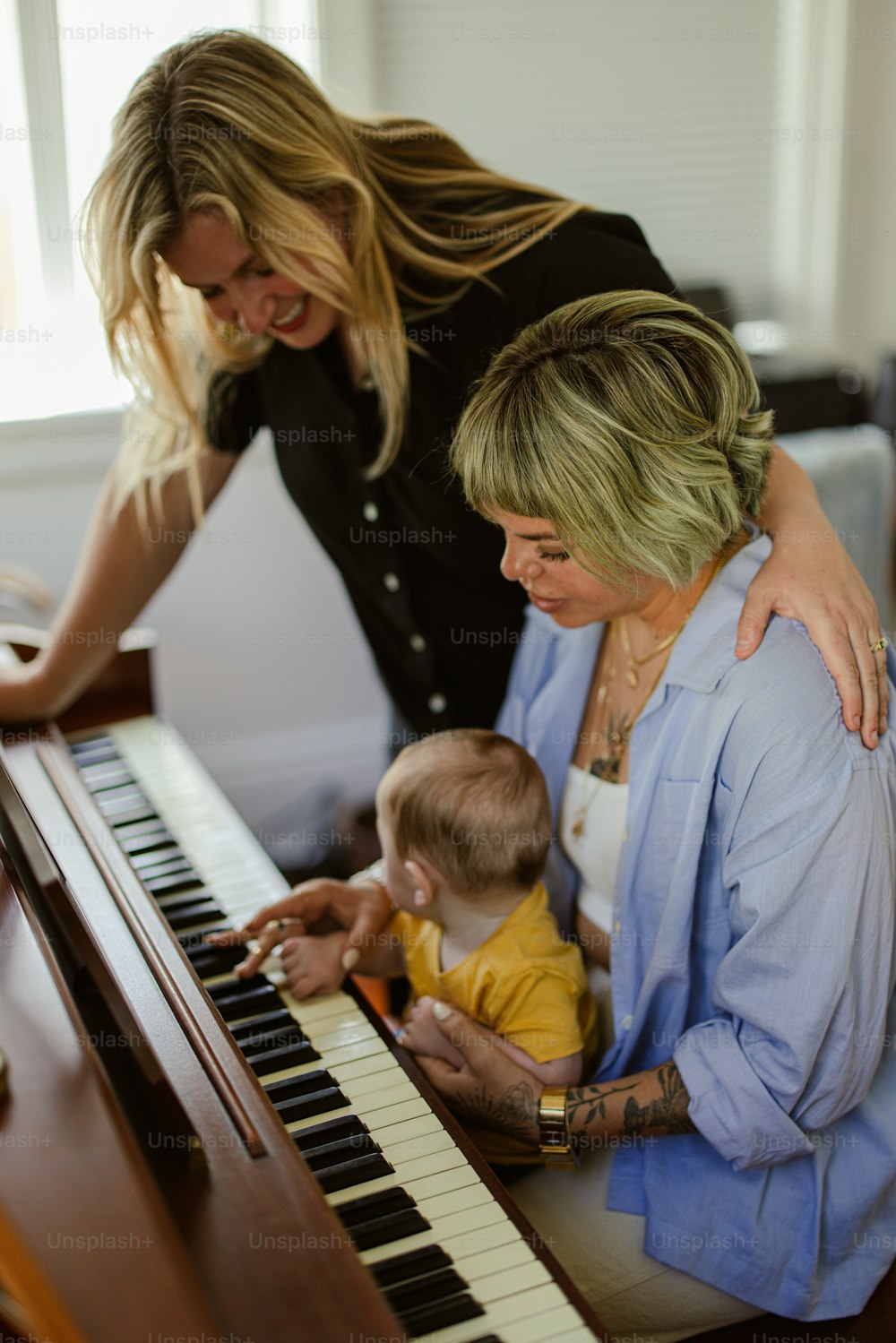 a woman playing a piano with a baby