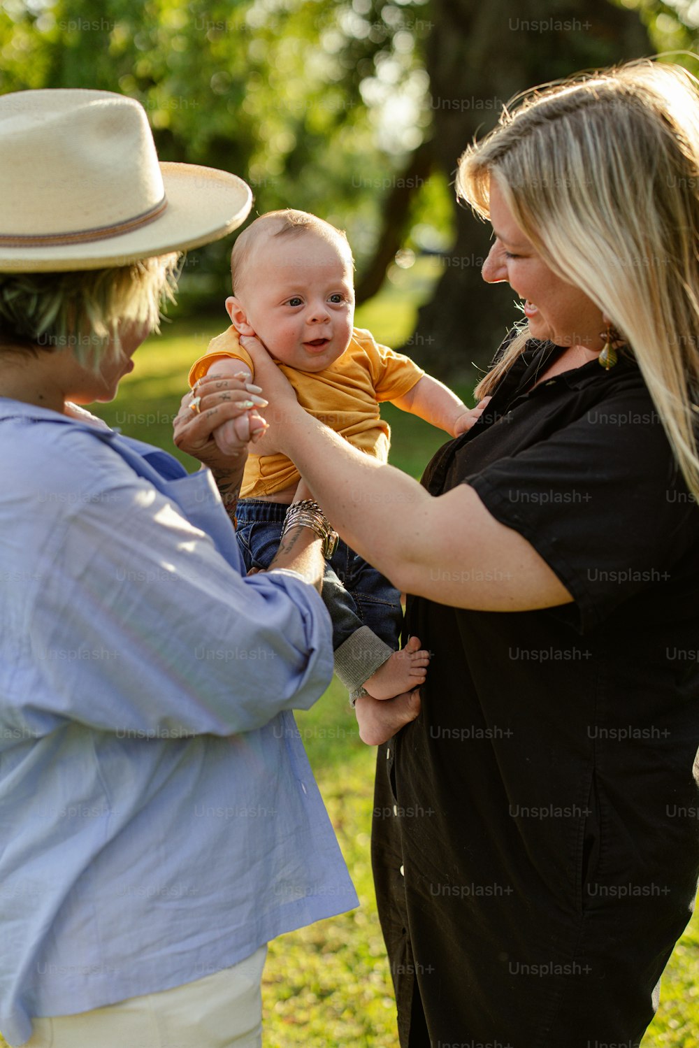 a woman holding a baby in a park