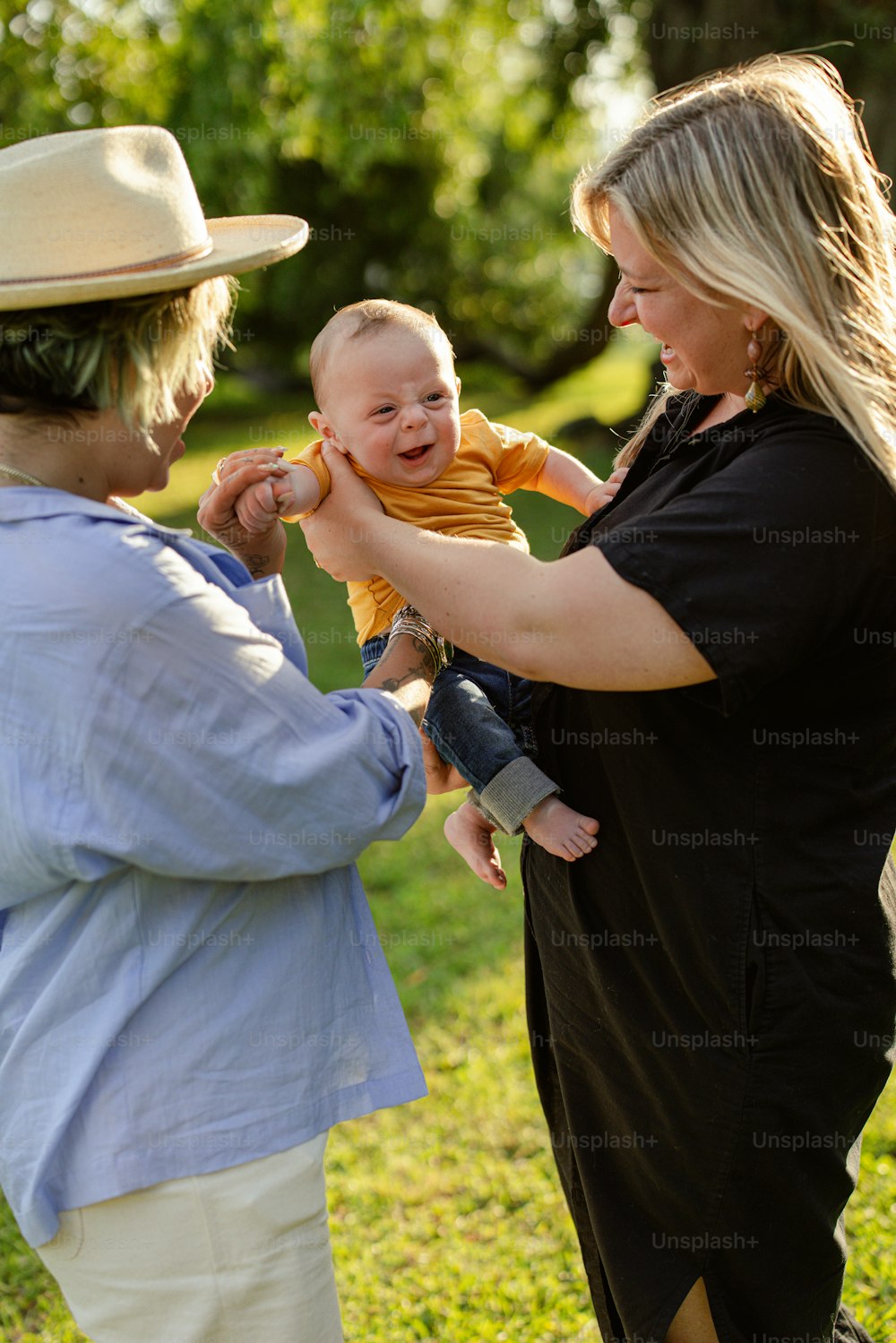 a woman holding a baby in a park
