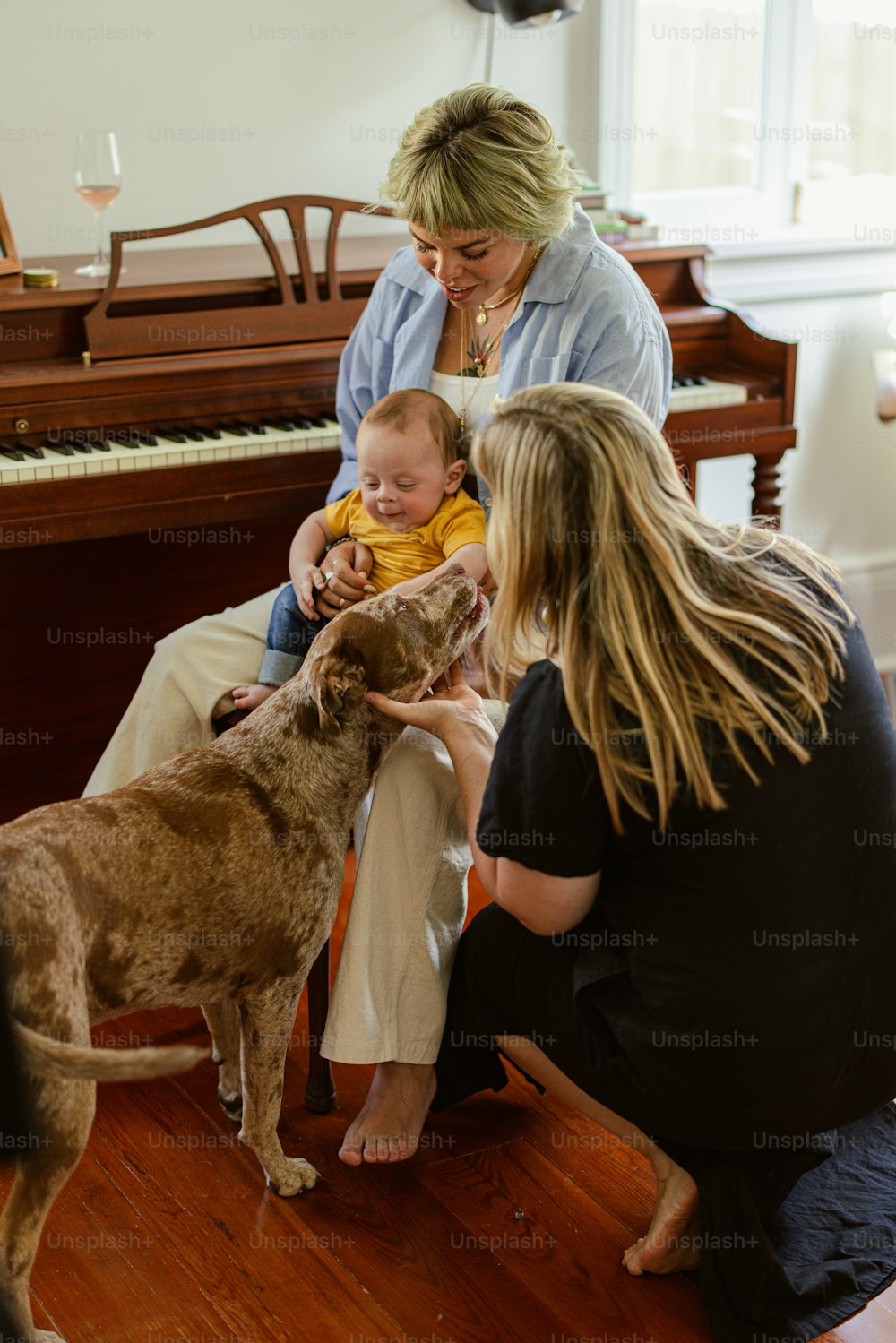 une femme assise sur une chaise avec un bébé et un chien