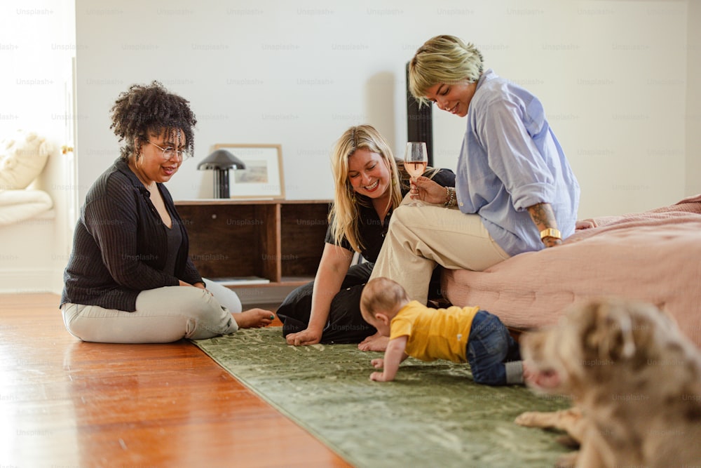 two women and a baby are sitting on the floor